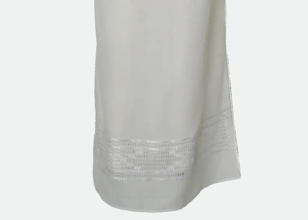 A long white or off-white dress with three-quarter sleeves and horizontal embroidered or lace-like bands across the bodice and skirt,CRAFTED BY ARTISANS OF BLOUSE ROUMAINE SHOP