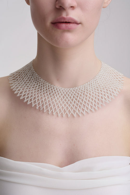 Close-up of a person wearing a detailed beaded necklace 