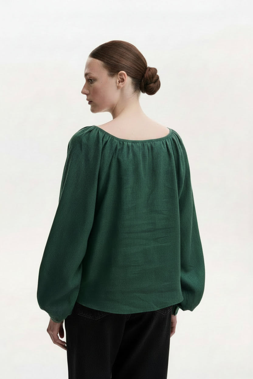 Green blouse with red tassels on a white background