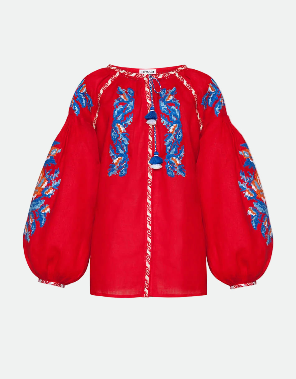 Red blouse with blue floral embroidery on a white background