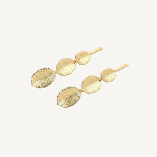 Gold leaf-shaped hairpins on a white background