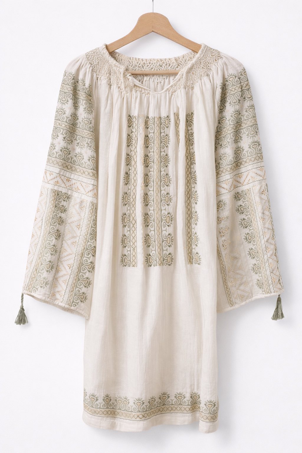 Beige embroidered dress on a wooden hanger against a white background