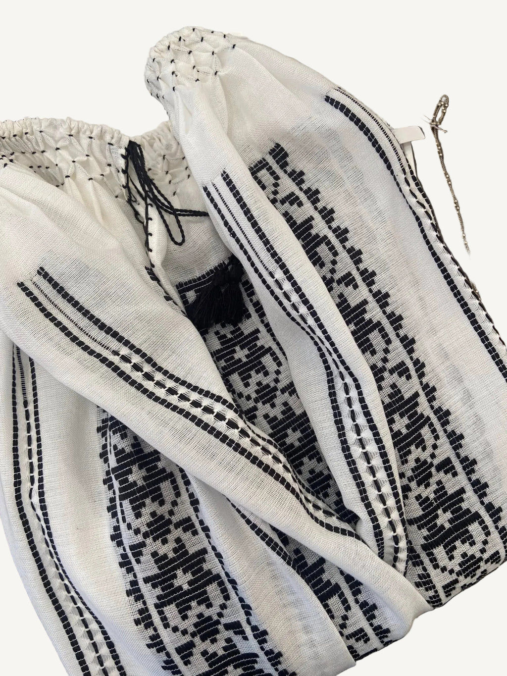 White fabric with black geometric pattern on a wooden surface