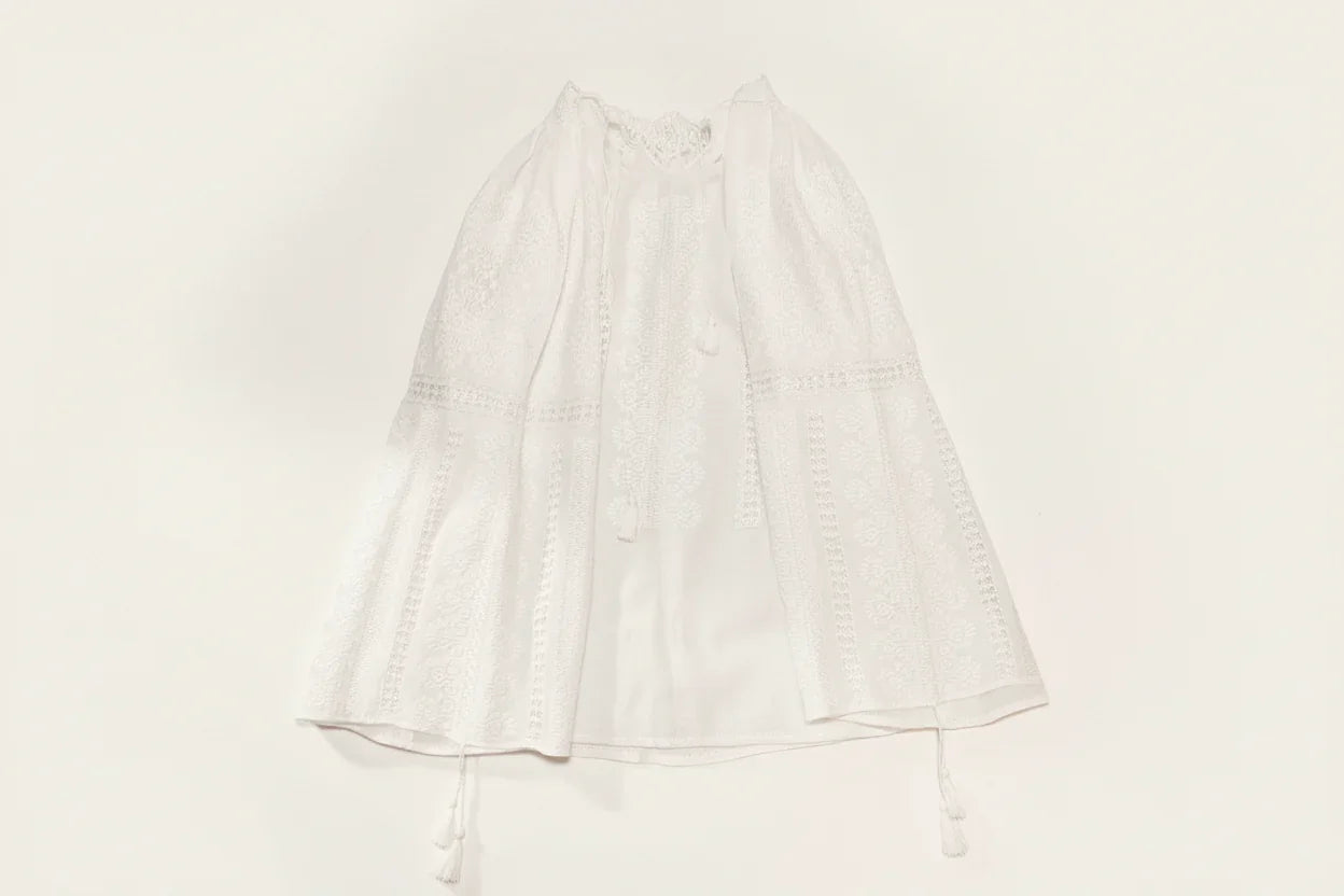 White embroidered Romanian Blouse  on a gray background