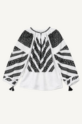 Black and white patterned blouse with long sleeves on a white background