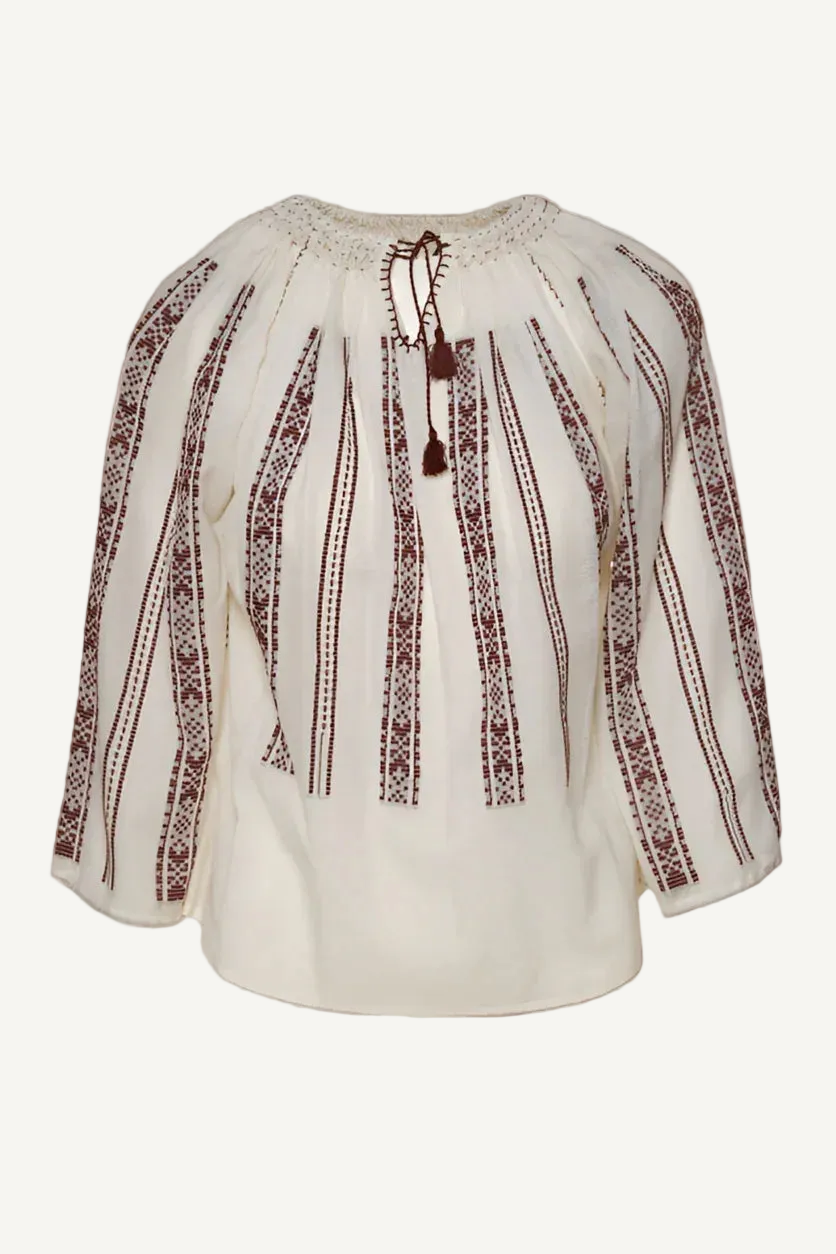 White blouse with brown embroidery on a white background