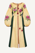 A long cream-colored dress with dark green side panels, featuring pink rose floral embroidery on the bodice and sleeves, and red tassels Blouse Roumaine Shop