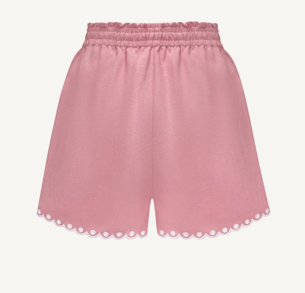 A pair of dusty pink shorts with an elastic waistband and scalloped eyelet lace trim along the hem, shown against a plain white background.