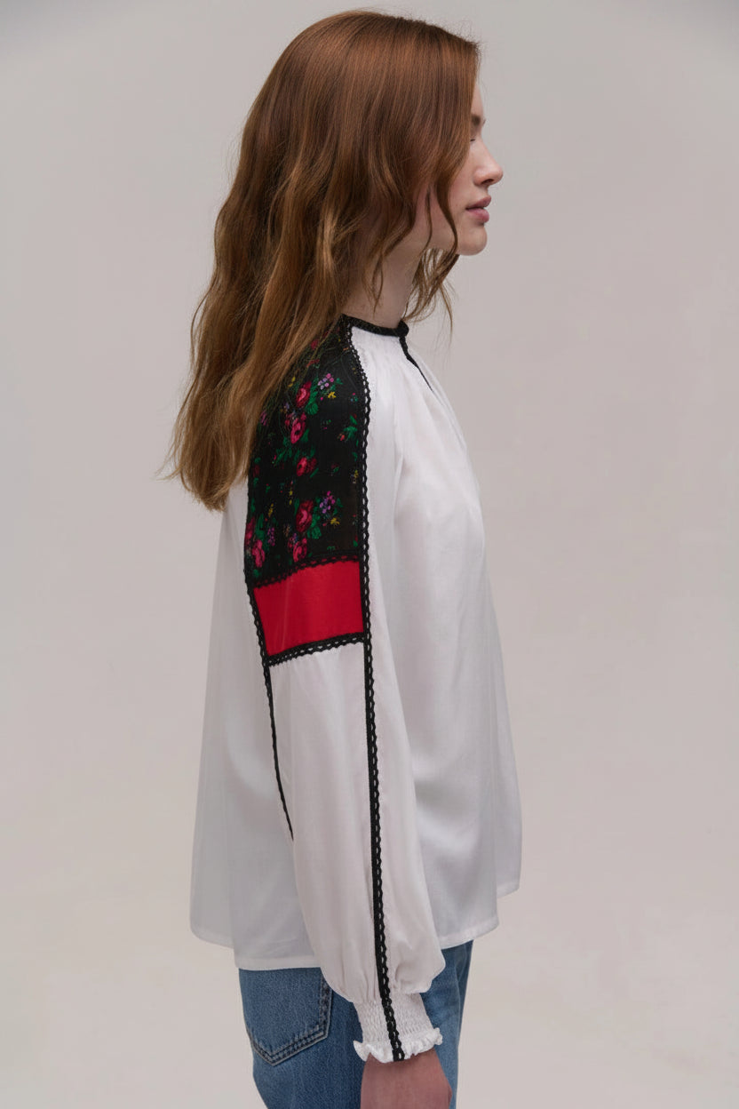 White blouse with embroidered sleeves on a plain background