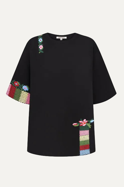 Black t-shirt with colorful floral embroidery crafted by artisans