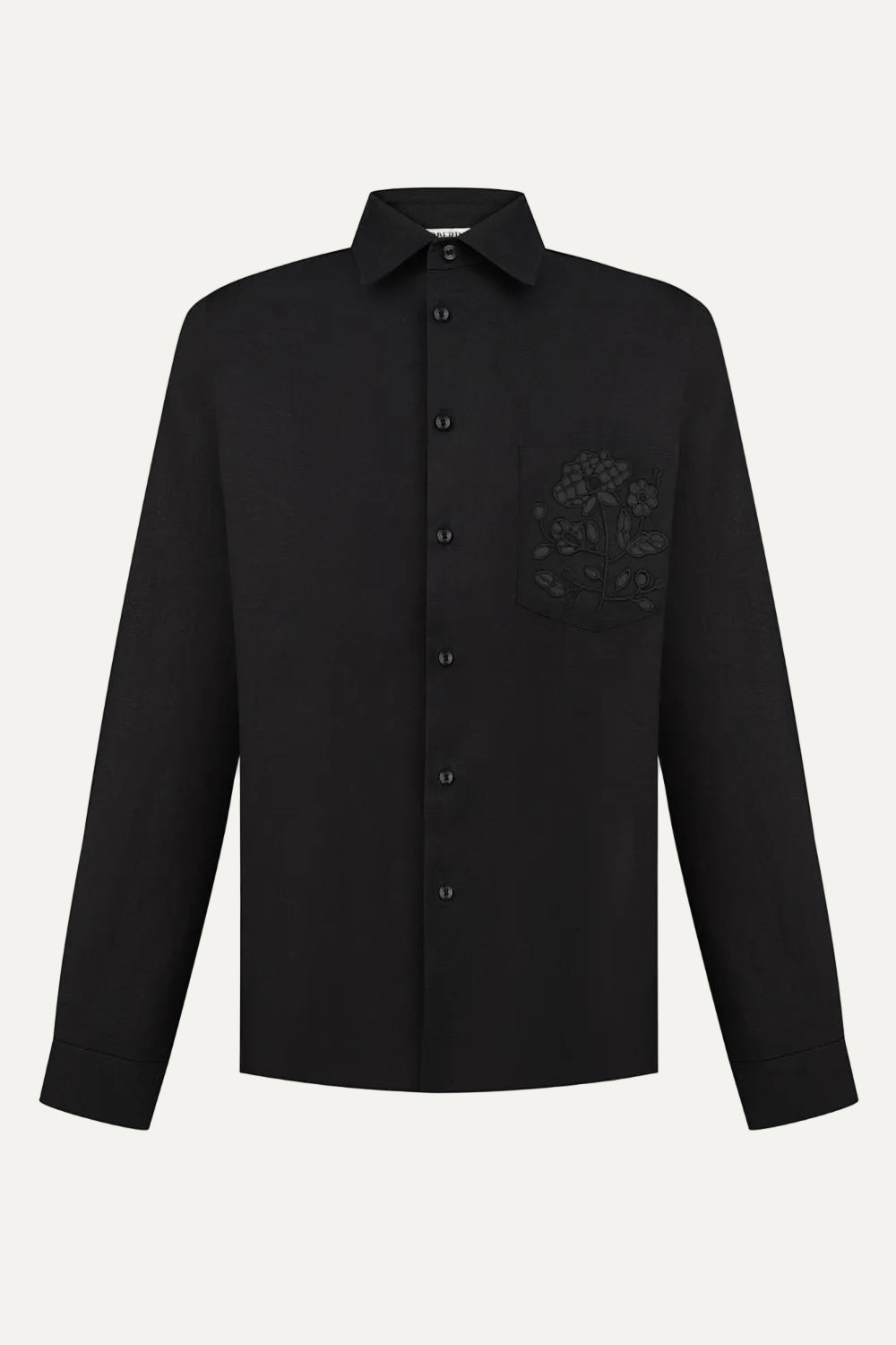 Black shirt with a floral embroidery on the chest against a white background