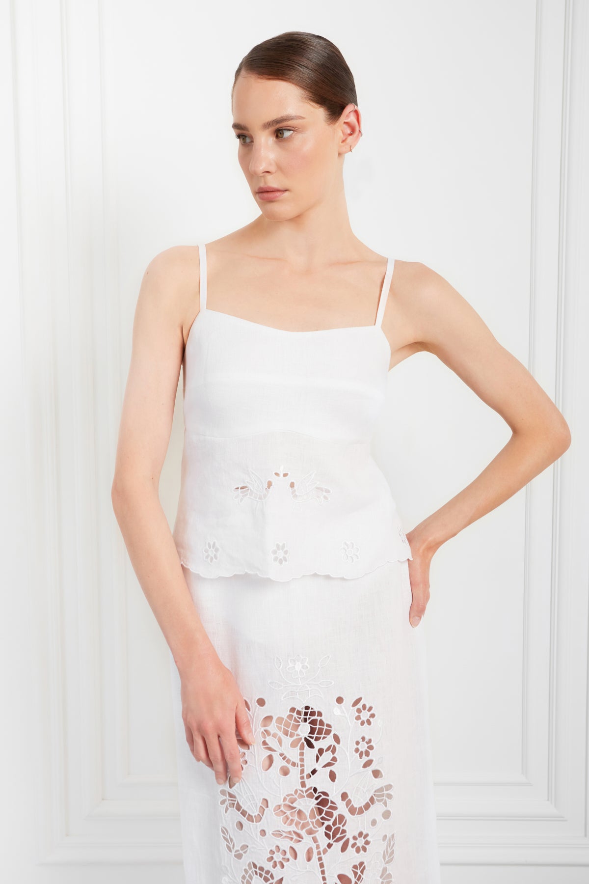 Woman wearing a white lace dress against a white background