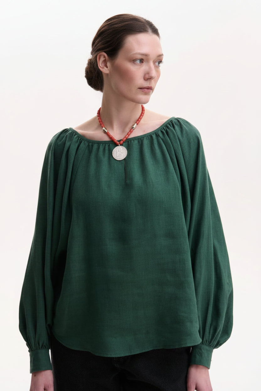Woman wearing a green blouse with long sleeves in linen green
