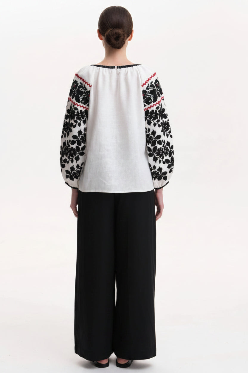 Back view of women’s embroidered Vyshyvanka blouseA woman - blouse with black floral embroidered sleeves Blouse Roumaine Shop