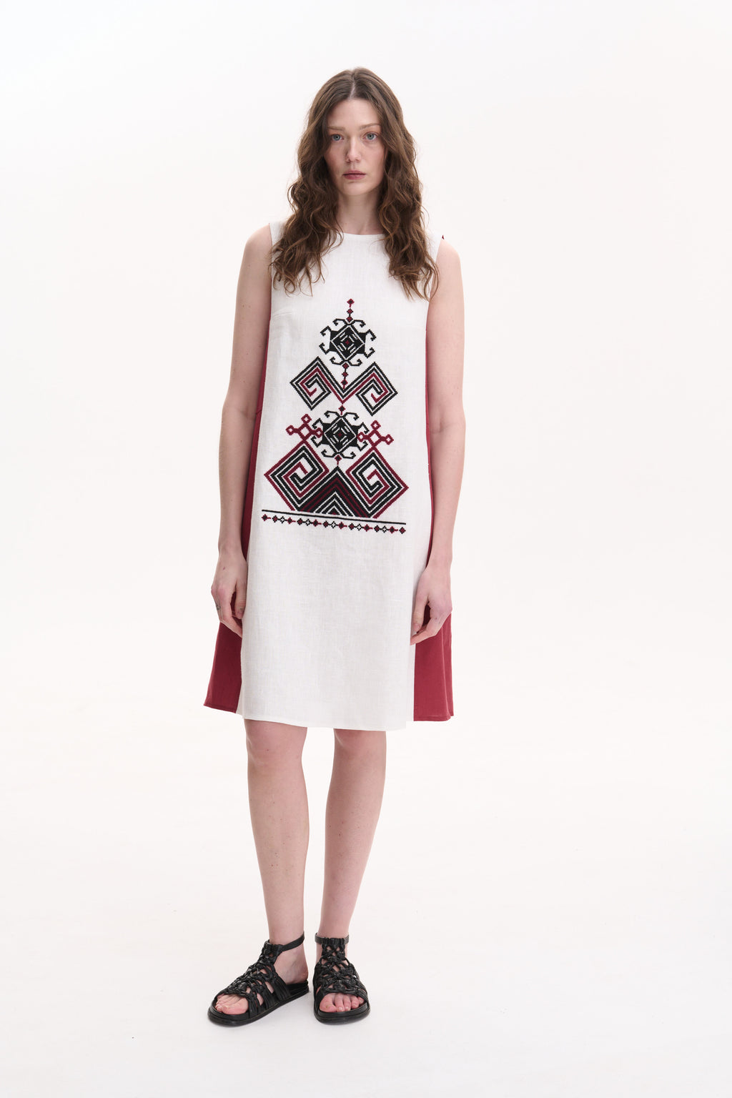 Woman wearing a sleeveless dress with geometric pattern on a white background