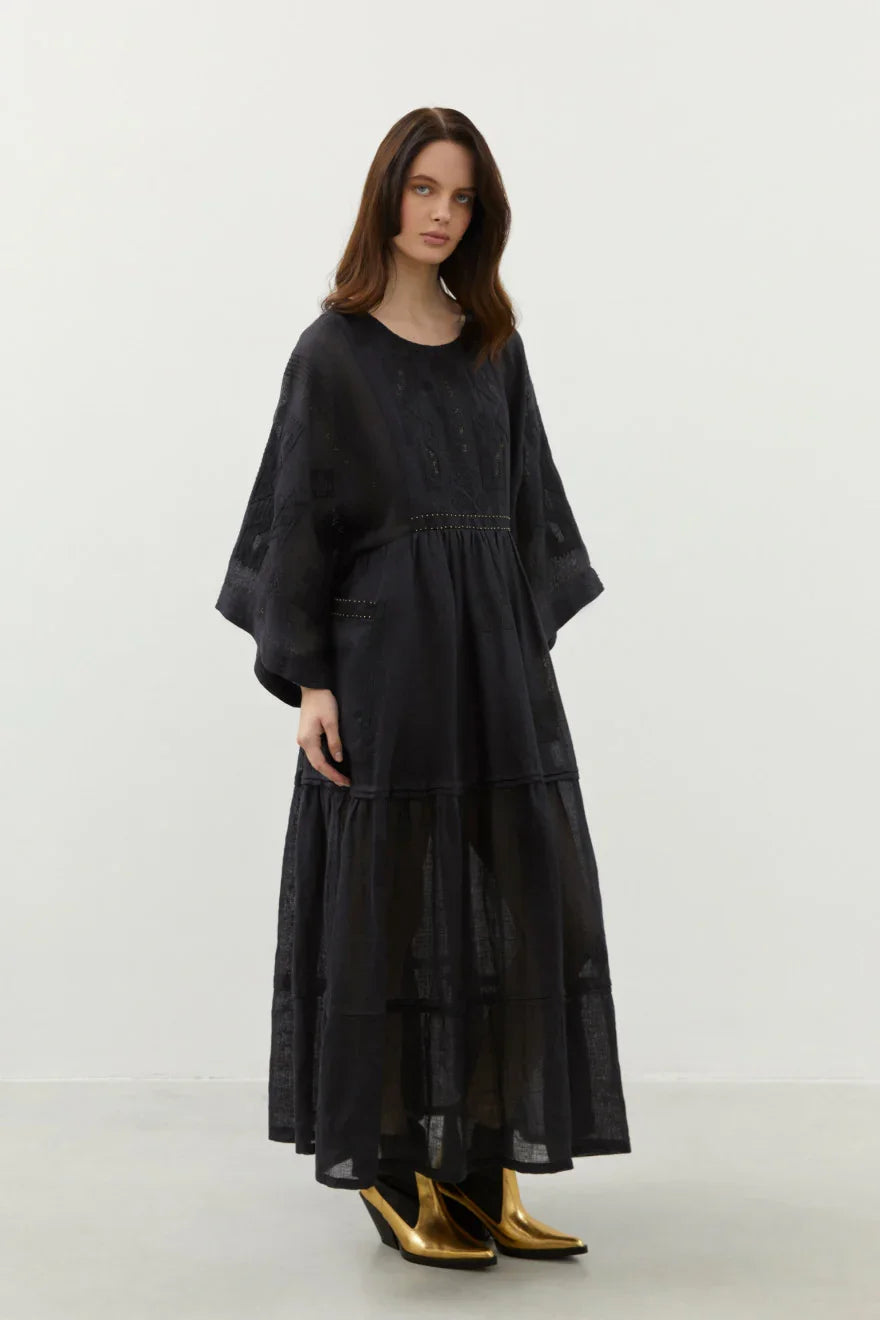 Embroidered maxi black dress with gold shoes on a white background