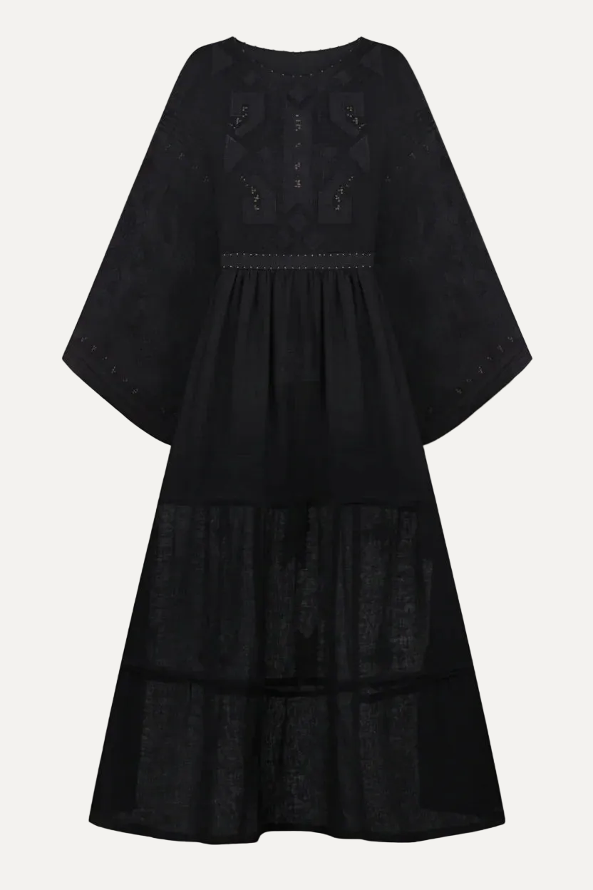 Black dress with smocked details on a light gray background