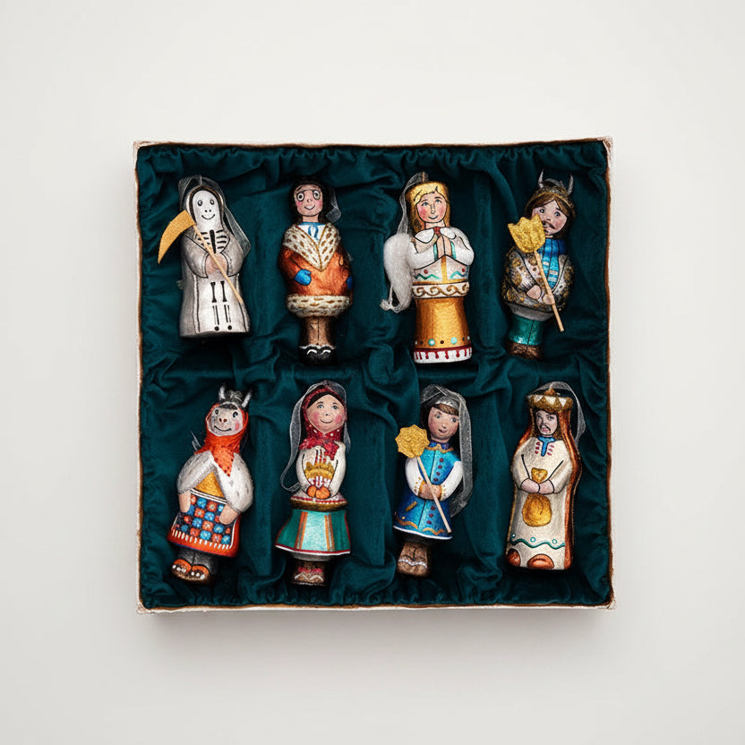 A set of eight hand-painted wooden nativity figurines displayed inside a square box lined with dark green velvet, set against a solid dark green background.