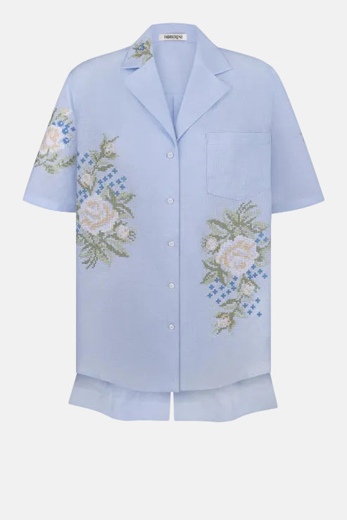 Light blue shirt with floral embroidery on a white background
