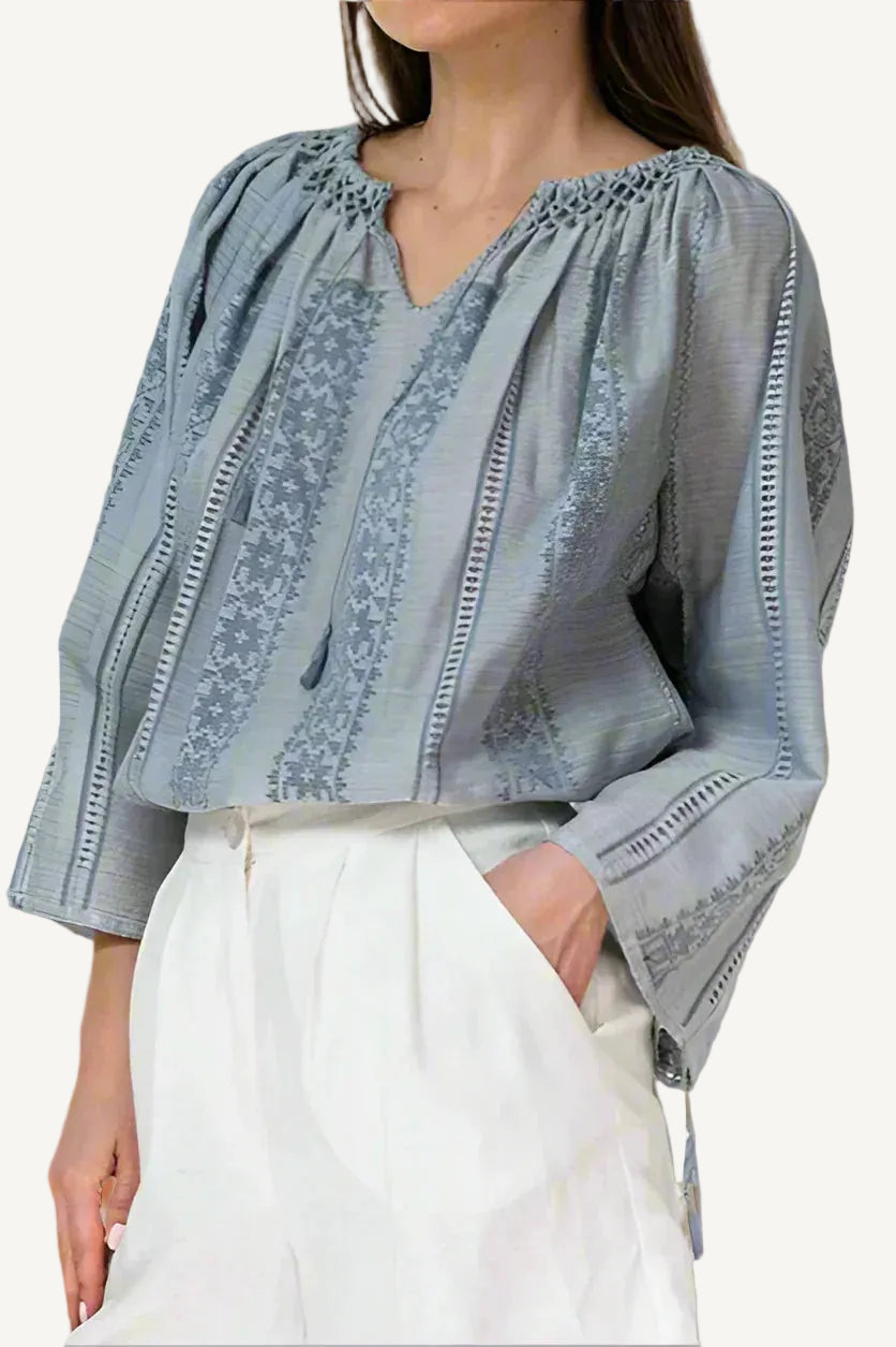 Woman wearing a light blue embroidered  Romanian blouse 