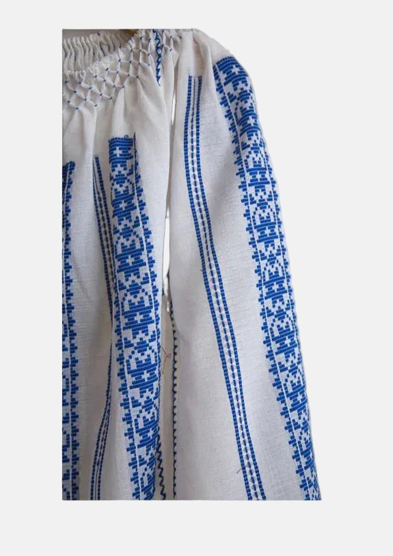White garment with blue embroidery on a light gray background