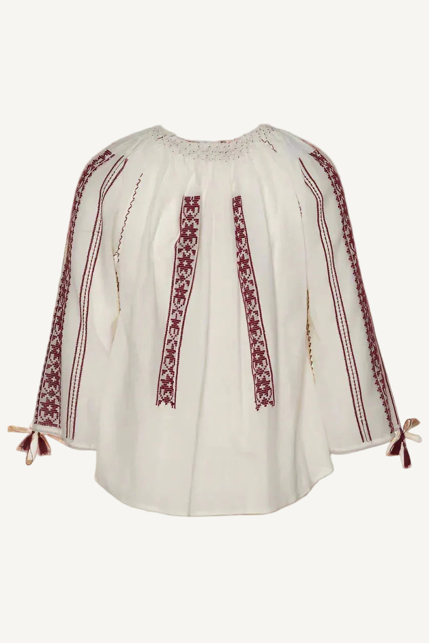 White blouse with red embroidery on a gray background