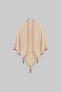 Beige poncho with tassels on a white background