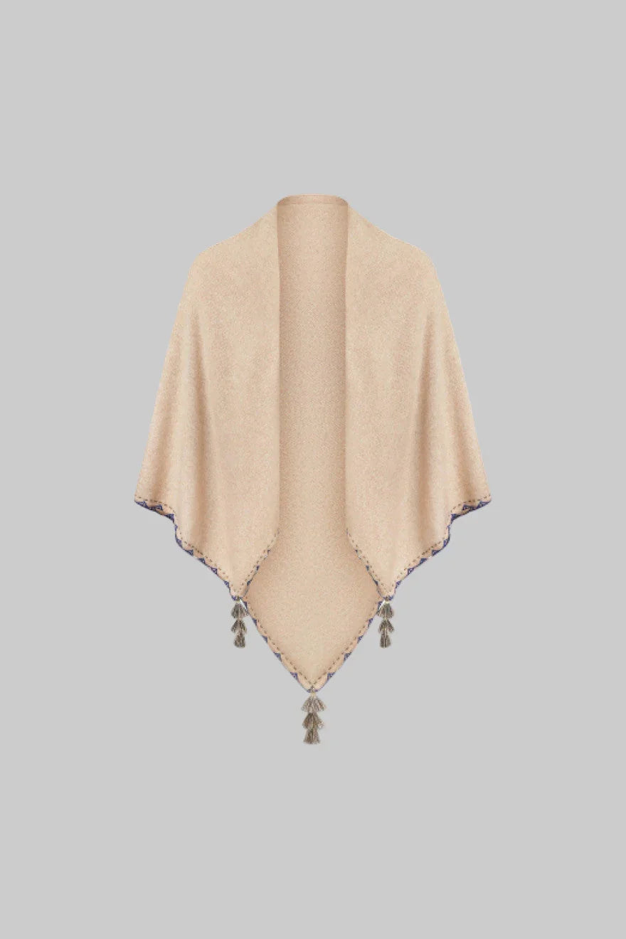 Beige poncho with tassels on a white background