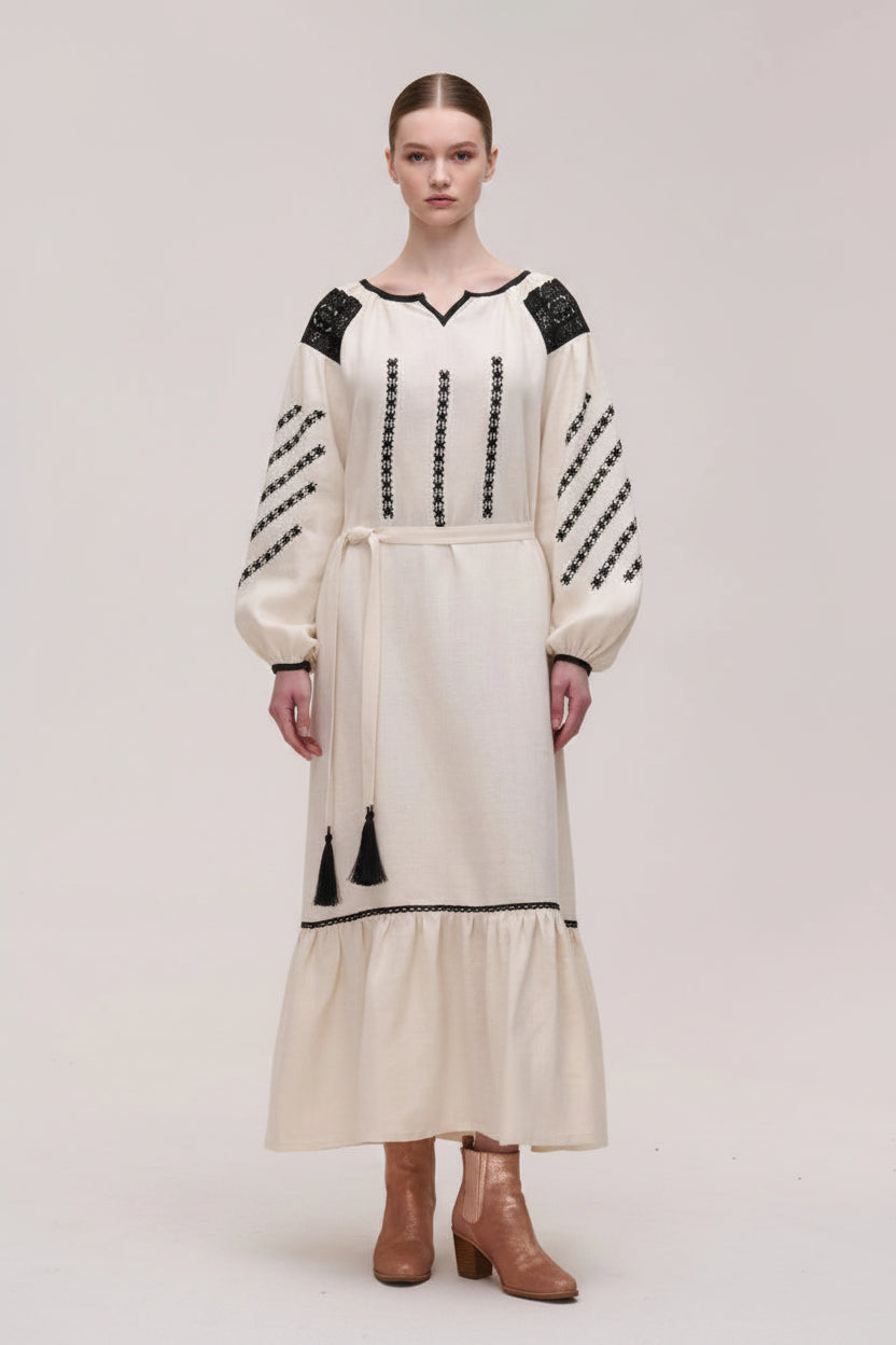 Woman wearing a white dress with black details on a plain background