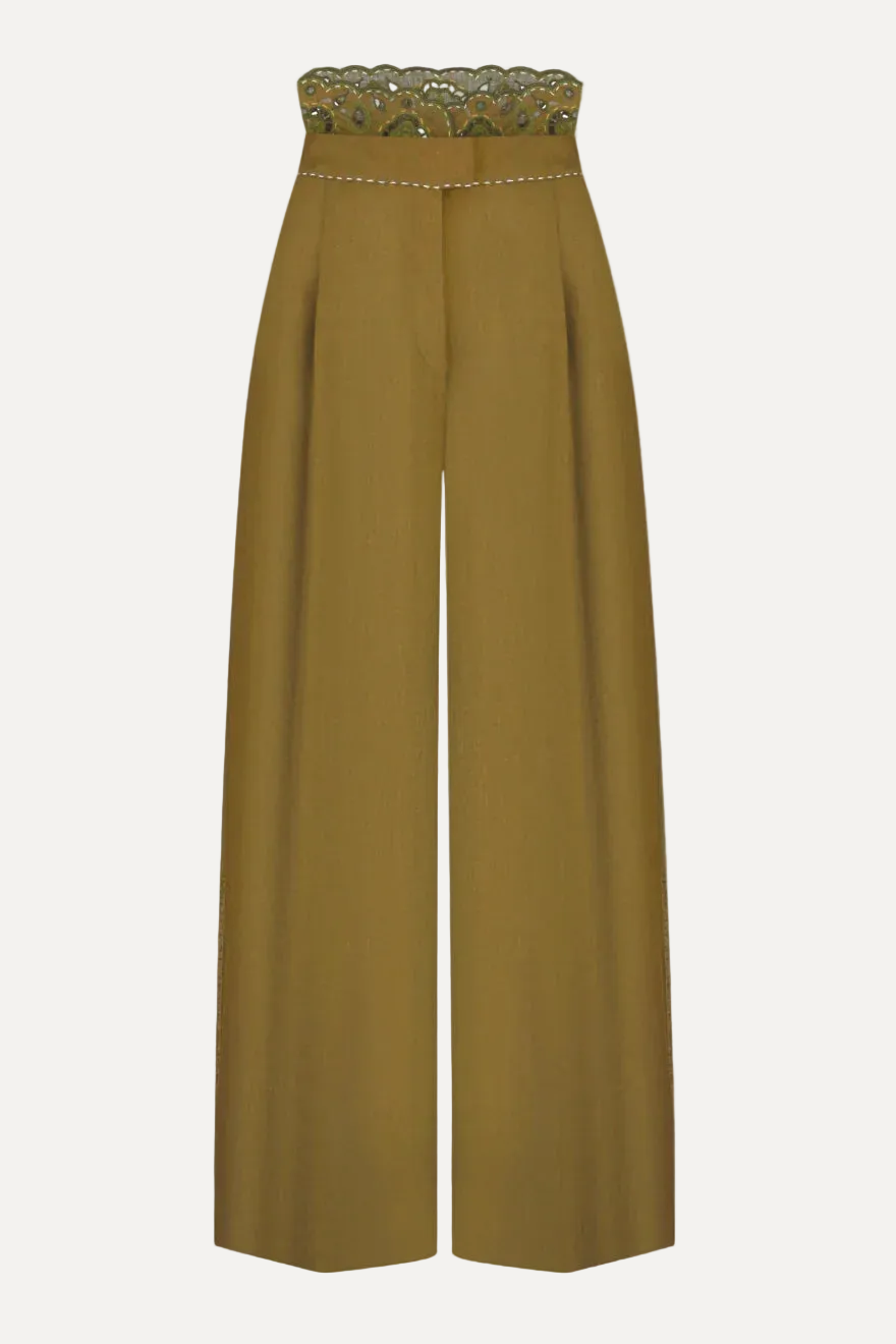 Mustard yellow pants with a decorative waistband on a light gray background