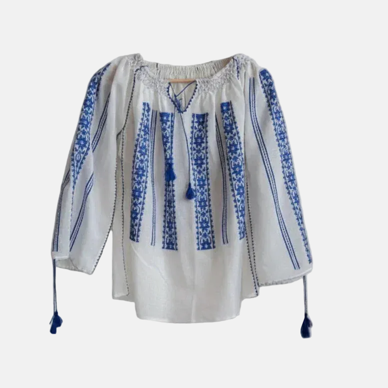 White blouse with blue embroidery on a light gray background