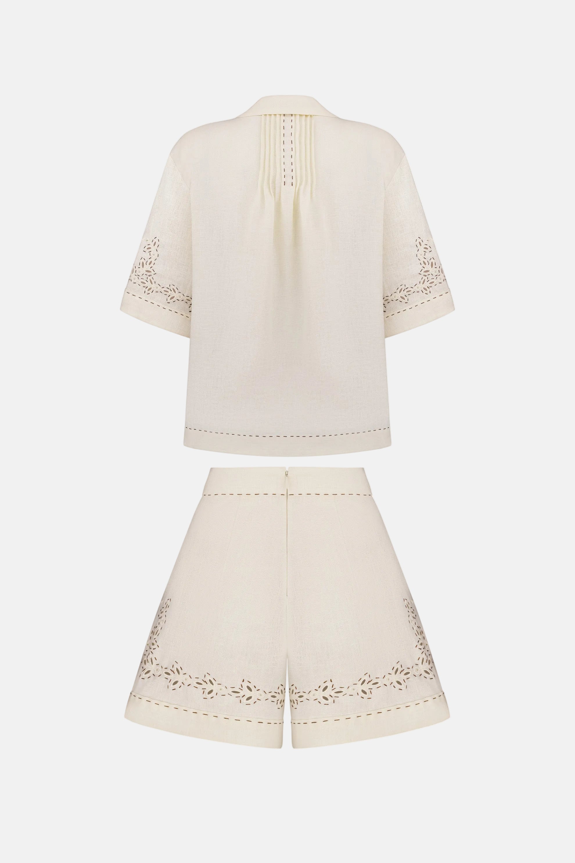 White outfit with embroidered details on a white background