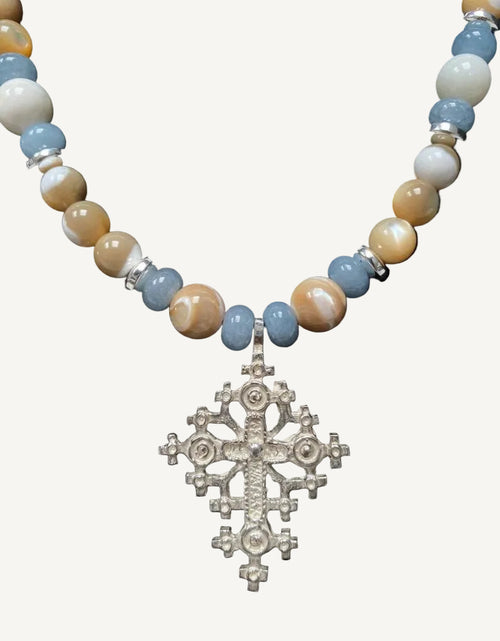 Necklace with beaded chain and Ethiopian cross pendant on a black background