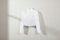 White shirt with floral embroidery on a white background