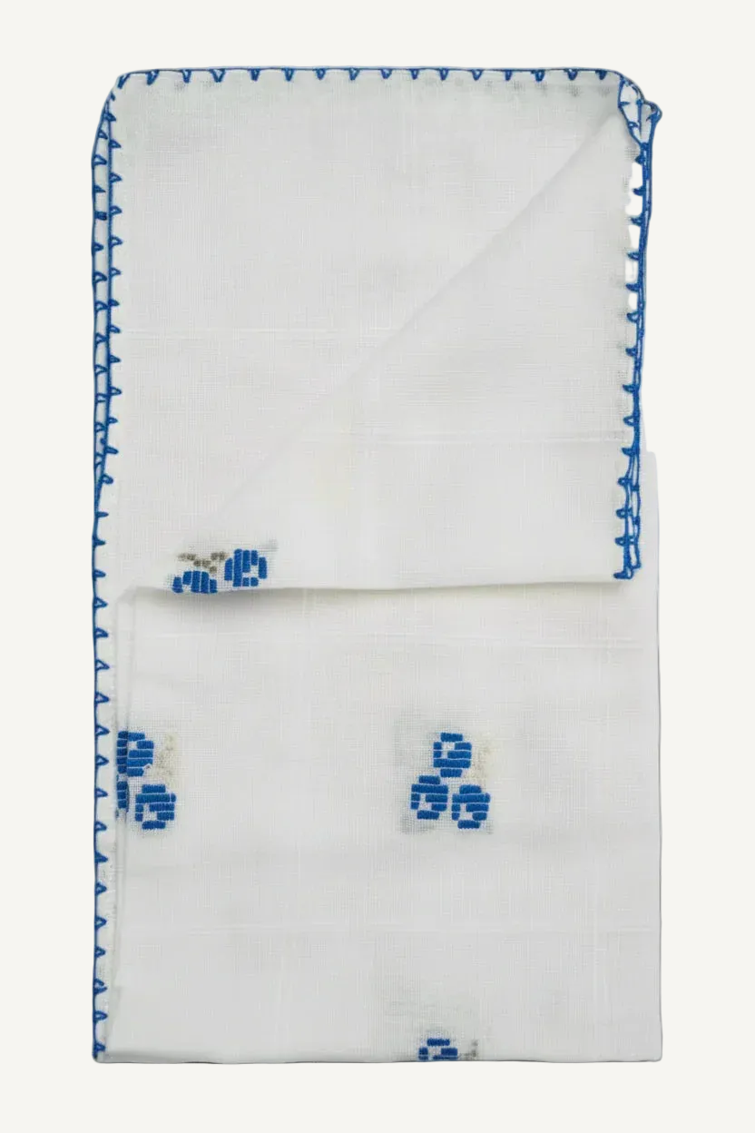 White handkerchief with blue embroidery on a light gray background