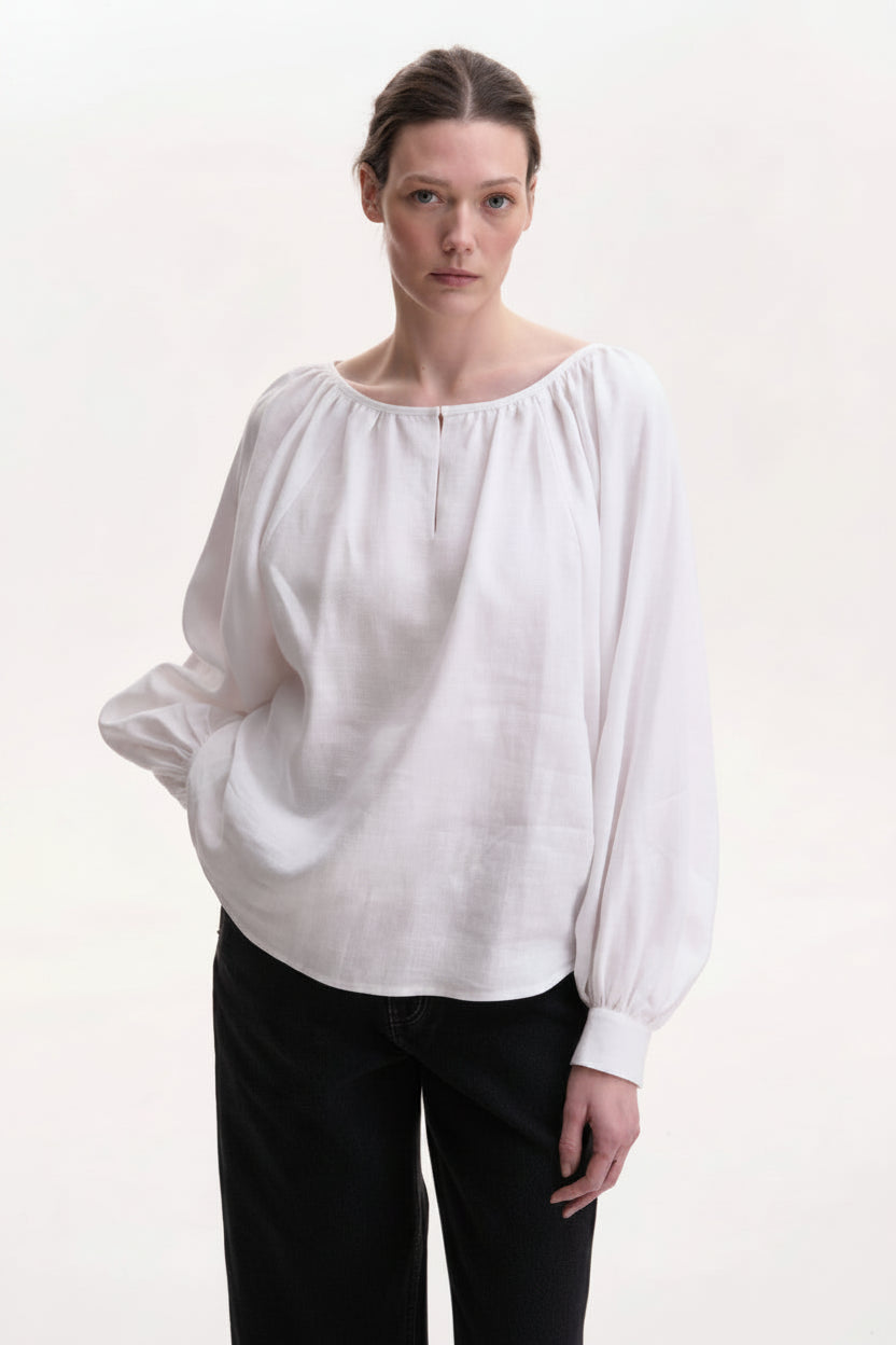 Woman wearing a white blouse handmade blouse roumaine shop. Crafted by artisans